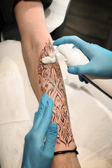 Tattoo artist applying moisturizing cream on a fresh tattoo