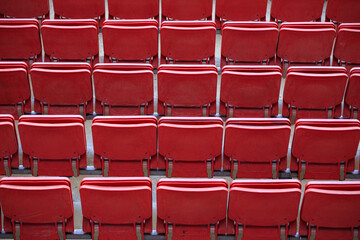 Fototapeta premium The empty seats in the stadium are red and arranged in rows