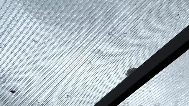 Heavy rain drumming on the transparent plexiglass roof. Beautiful rainy scene on summer day. Concept of tranquility nature scene. Close up Slow motion