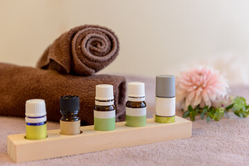 エステサロン、エッセンシャルオイル、アロマオイルとピンクの花、タオル、ベッド