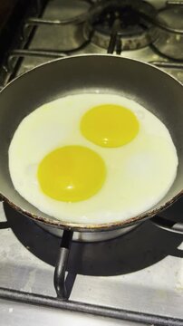 dos huevos estrellados fri&eacute;ndose en un sart&eacute;n