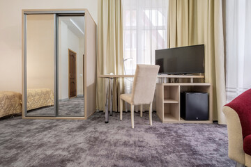 Modern hotel room with desk and armchairs
