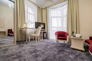 Modern hotel room with desk and armchairs