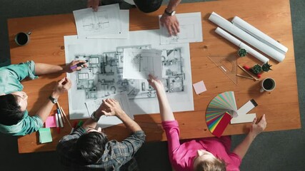 Top down view of manager looking at document while team planing building. Aerial view of skilled architect engineer holding and send blueprint at meeting table project plan and blueprint. Symposium.