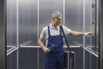 Professional plumber in the elevator