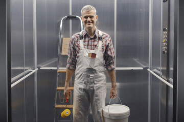 Happy professional painter posing in the elevator © stokkete