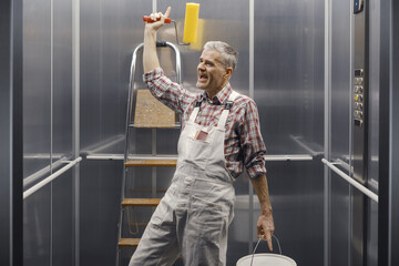 Funny professional painter singing in the elevator © stokkete