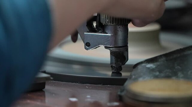 Diamond Polishers at Work at the Wheel in the Diamond Polishing Factory.The machine for diamond cutting. A polisher brillianteers the final facets of a gem attached to a drop on rotating cast iron lap