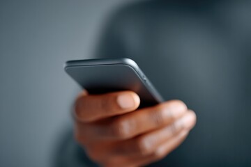 close-up of person hand tightly gripping smartphone focus on fingers background softly blurred for emphasis