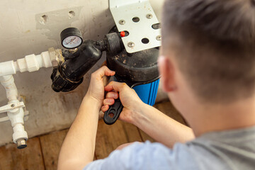 Man unscrews the filter flask with black plastic key to replace the cartridge