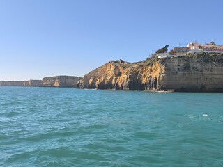 Majestic rock formations line the coast, adding texture and depth to the landscape with the ocean...