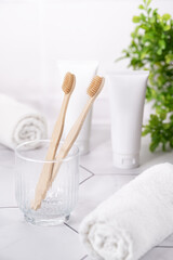 White Cosmetic Tubes and Bamboo Toothbrushes in Bright Minimalist Bathroom Scene