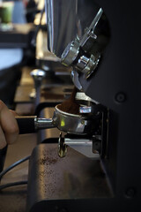 mano de barista echando café molido al filtro 