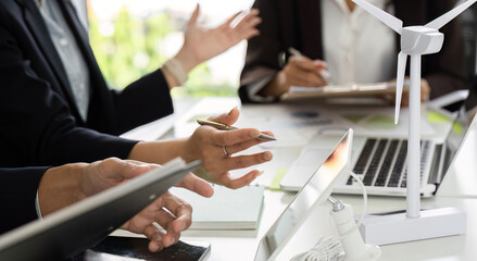 Team Collaboration on ESG Strategies. A diverse team discussing renewable energy initiatives with a...