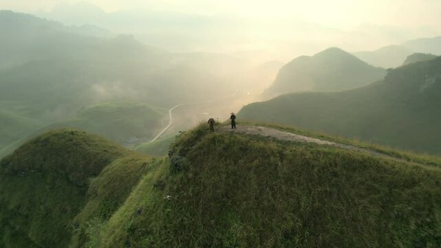Landscape of Ba Guang grass hill, Mountain range with fog and villager bringing horse to graze on the mountain in the morning