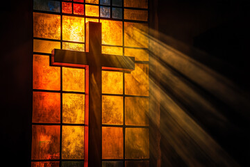 Naklejka premium The cross on the stained glass window of the church, illuminated by the rays of the sun, beautifully symbolizes faith and spiritual light