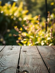 Wooden table top on blur background of green garden with bokeh sunlight. 
