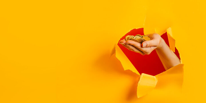A full handful of euro cents on a yellow studio background with a hole. Saving money, resources saving concept. Copy space.