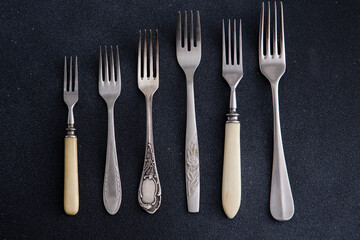 Forks on a black background. Set of old different cutlery for food. Silver fork. Collection of...