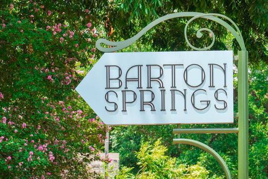 AUSTIN, TEXAS, USA - AUGUST 9, 2024: Barton Springs in Austin, Texas, USA. Natural water springs located at Barton Creek on the grounds of Zilker Park. Vintage Art Deco sign at Barton Springs Pool.