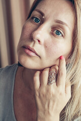 Beautiful mid age woman showing red shellac manicure on nails .