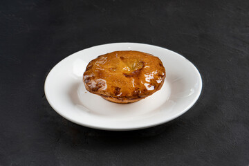 Juicy fresh ruddy pastries on a white plate on a dark gray background