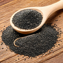 Ground and whole poppy seeds pile in wooden spoon with dried box, isolated 