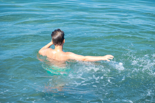 young boy play in open water, ocean on sunny summer day, Water activities, prevent drowning, aquatic adventures foster curiosity and love for environment in kids