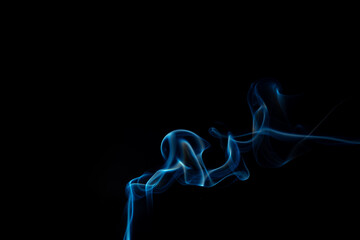 Fototapeta premium Wispy blue smoke wave flowing against a black background, creating a sense of mystery and elegance. Abstract and atmospheric concept. Swirling, writhing smoke to overlay on your photos