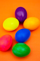 Easter Flat Lay with Multicolor Eggs in Rustic Bowl Isolated On Orange
