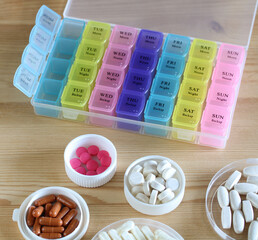 Weekly pill organizer box with various pills for daily medication