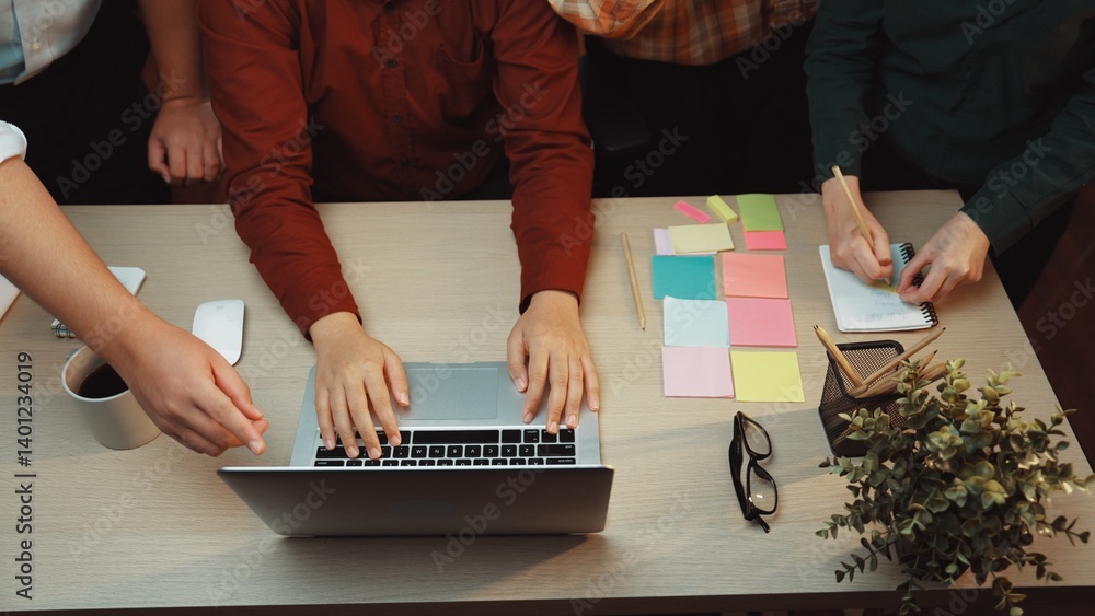 Poster a dynamic workspace featuring a laptop and vibrant sticky notes, highlighting hands of individuals c