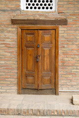 carved wooden door with padlock