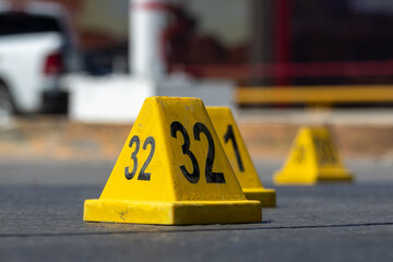 Close-up of evidence marker number 32 at a crime scene on an urban road