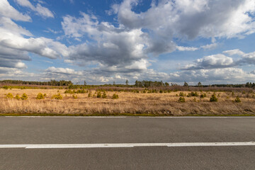 A road with a white line and a blue sky in the background