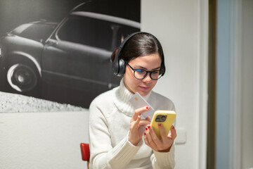 Young woman paying with credit card on smartphone at home.