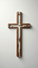 A wooden cross with a jagged edge on top, affixed to a white wall.