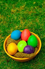 Colorful Easter Eggs in Orange Bowl on Grass