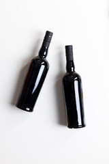 
Two sleek black glass bottles, without labels, lying side by side on a clean white background. The bottles have a smooth, modern design and are viewed from above, creating a minimalist, stylish look.