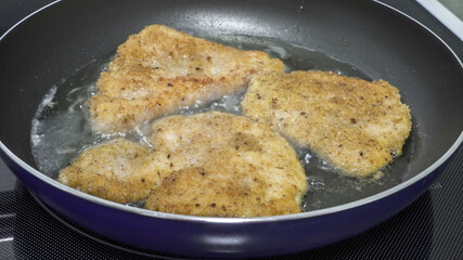 Crispy fried chicken cooking in a skillet on a stovetop