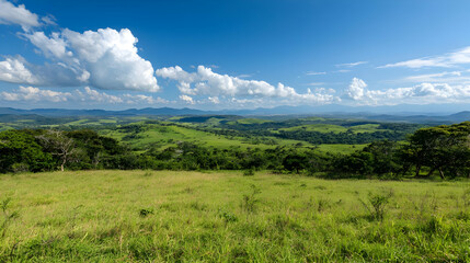 Obraz premium Panorama Of Lush Green Fields And Hills Under A Blue Sky