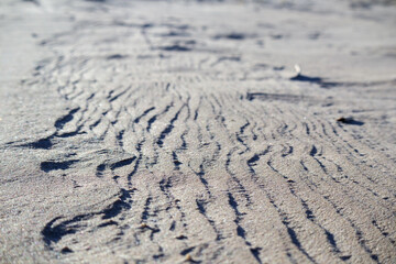 
sandy surface with pronounced wavy patterns and shadows.