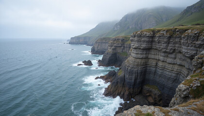 Dramatic seashore cliffs against a misty ocean background  