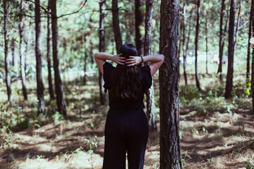 Mujer latina en el bosque parada de espaldas