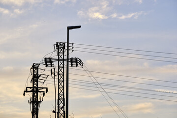 Silhouetted power lines and streetlight against a serene dusk sky
