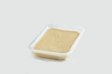 open plastic pack containing macco of fava beans. Pack-shot of transparent plastic box on white background.