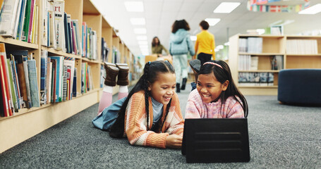 Students, library and girls with tablet, funny and online learning with education, smile and humor on web. Children, kids and friends on ground, tech or storytelling with break, joke and knowledge