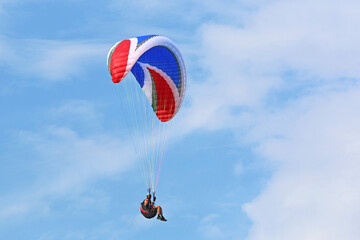 Paraglider flying in a blue sky	