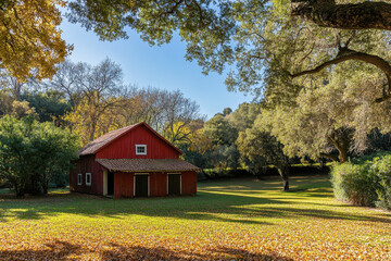 Obraz premium A red barn nestled among vibrant autumn trees and fallen leaves.