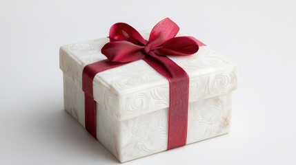 Obraz premium A white marble gift box with intricate carvings sits elegantly with a red ribbon wrapping, emphasizing its premium, luxurious design.